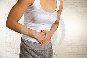 Close up of beautiful woman body suffering from stomachache, period pain and menstrual cramps