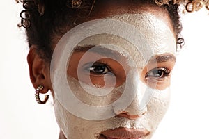 Close-up of beautiful woman with moisturising face mask, cares of skin beauty.