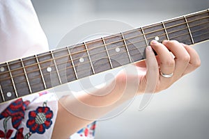 Close up beautiful woman playing acoustic guitar.woman`s hands playing acoustic guitar