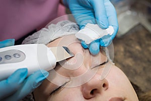 Close-up Of Beautiful Woman Receiving Ultrasound Cavitation Facial Peeling. Ultrasonic Skin Cleansing Procedure. Beauty Treatment