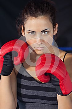 Close up of a beautiful woman in red boxing gloves