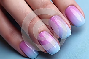 Close up of beautiful woman\'s fingernails with pastel blue, pink and purple ombre colored nail color design