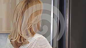 Close up of a beautiful woman smiling looking in the fridge