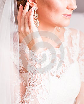 Close up of beautiful woman wearing shiny diamond earrings.