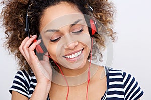 Close up beautiful young african american woman listening to music with headphones