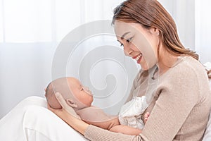 Close up beautiful young asian mother holding her newborn one month baby sleep on herlap. Healthcare and medical.  Lovely asia