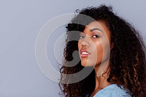 Close up beautiful young black woman against gray wall