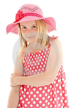 Close up of beautiful young blonde girl wearing big pink floppy hat and a polka dot dress. Isolated on white studio background