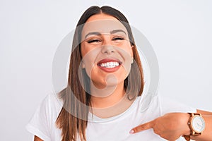 Close up of beautiful and young brunette woman standing over isolated white background with surprise face pointing finger to