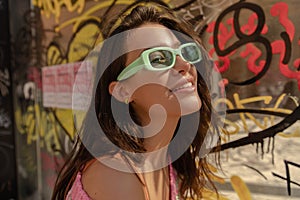 Close-up of beautiful young caucasian female in sunglasses looking at distance outside.