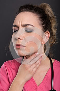 Close-up of beautiful young doctor having a throat ache