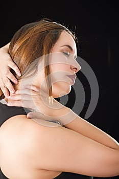 Close up of a beautiful young lady Suffer crick after workout in a black background