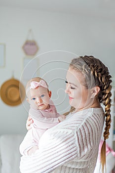 Close-up. Beautiful young mother holds the hands of her little daughter. Baby. Newborn