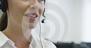 Close up of beautiful young operator woman standing and wearing headset at the bright office space