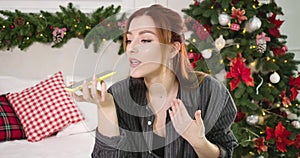 Close-up of beautiful young red-haired woman talking on the phone on New Year. Portrait of gorgeous Caucasian lady using