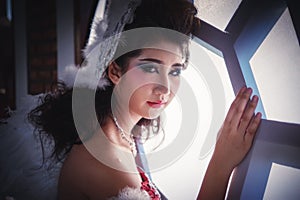 Close up of beautiful young woman posing near window