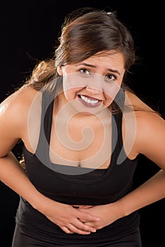 Close up of a beautiful young woman with stomach ache or nausea in a black background photo