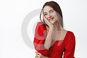 Close up of beautiful young woman in stylish red dress, glamour romantic outfit for date or evening party, gazing