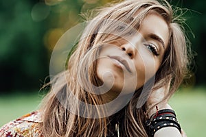 Close up Beautiful young woman wearing bohostyle clothes posing in the rays of the evening sun, sunset. Boho style