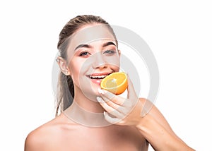 Close up beauty portrait of an excited attractive half naked woman holding orange slices at her face and looking at camera isolate