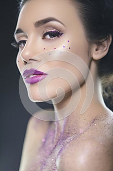 Close up beauty portrait of a fantasy art theme: Star Wars cosplay. Princess Leia hairstyle with purple glitters and stars all