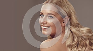 Close up beauty portrait of a laughing beautiful half naked caucasian woman with long blonde hair isolated over light