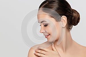 Close up beauty portrait of a laughing beautiful half naked woman applying face cream and looking away