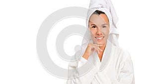 Close-up beauty portrait of a woman in a white towel on her head and a white robe, smiling