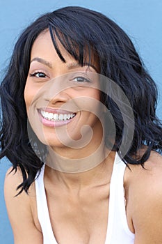 Close up beauty portrait of a young and attractive African American black woman with perfect skin, softly smiling.