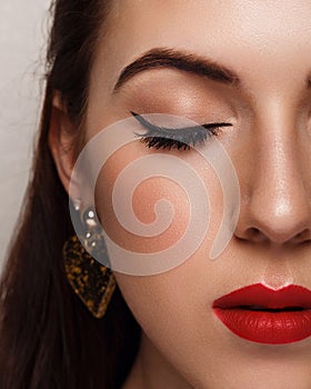 Close-up beauty portrait of young woman with beautiful bright makeup. Modern smokey eyes with colorful eyeshadows.