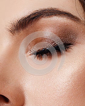 Close-up beauty portrait of young woman with beautiful nude makeup. Modern smokey eyes with colorful eyeshadows