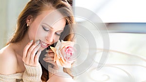 Close-up beauty young model girl face with rose flower near lips. Skincare facial treatment concept.