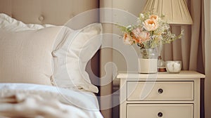 Close up of bedside cabinet near bed with beige bedding