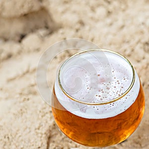 A close-up of a beer cup on the sand photo