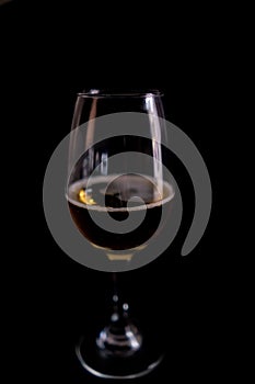 Close-up of beer in a glass goblet with black background