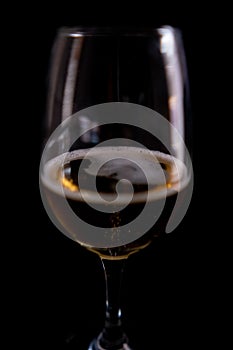 Close-up of beer in a glass goblet with black background