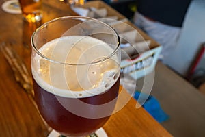 Close-up of beer glass placed on a wooden table in a restaurant