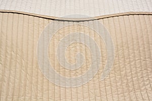 Close up of beige bed cover comforter