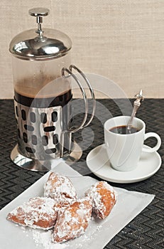 Close up of beignet fritters and french coffee press