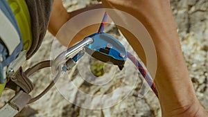 CLOSE UP: Belayer pulls back on the safety rope running through a GriGri system.