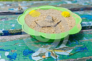 A close-up bench on a bench and a sieve filled with sand