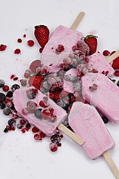 Close up of berry yogurt ice cream with wooden stick on white background photo