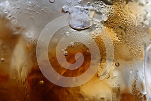 Close-up beverage cola and cubes ice refreshing cool in glass, black cola soda in glass with ice cubes for refreshments feel