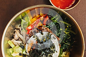 Close up of Bibimbap or Korean rice dish served on table.