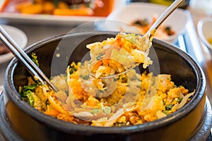 Close up of Bibimbap, traditional Korean food served in warm bowl and cooked by mixed rice with vegetables, eggs and meat.
