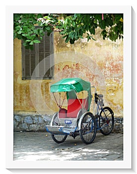 Close up bicycle rickshaw parked under tree in Hoi An street, Vietnam