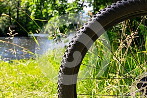 Close-up bicycle wheel on the background of green grass