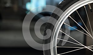 Close up of bicycle wheel and spokes. Bokeh in background. Photographed at Japan House, London.