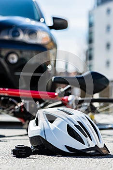 Close-up of a bicycling helmet on the asphalt after car accident