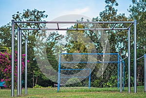 Close-up big high outdoor metal empty pull-up bar for doing sports, warm-up before playing near football goal. Summer